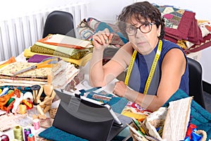 Beautiful mature seamstress using tablet computer