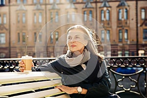 Beautiful mature woman in autumn park flooded with sunlight