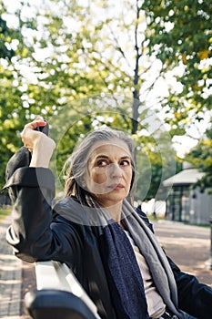 Beautiful mature woman in autumn park flooded with sunlight