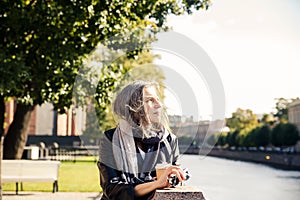 Beautiful mature woman in  autumn park near  embankment