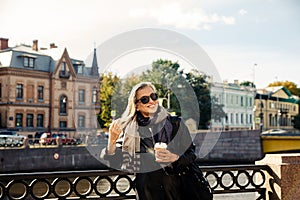 Beautiful mature woman in  autumn park near  embankment