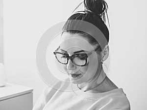 Beautiful mature woman in big glasses. Face portrait of adult lady working at home.Black and white.