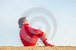 Beautiful mature woman doing gymnastics on a sandy beach on a background