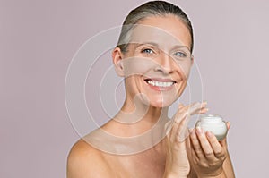 Woman holding jar of moisturizer photo