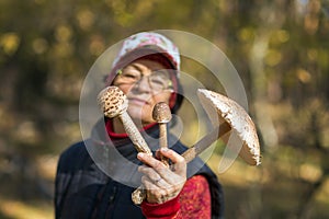 Beautiful mature woman holding three different mushrooms in her hands