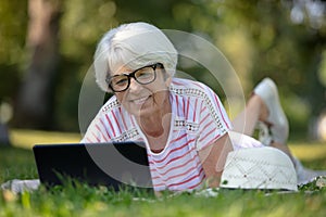 beautiful mature woman on laptop pc in park