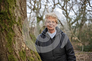 Beautiful mature woman outdoors walking in a woodland in winter