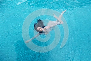 Beautiful mature woman in the prime age with dark curly hair in a bikini is running floating weightless elegant happy floating