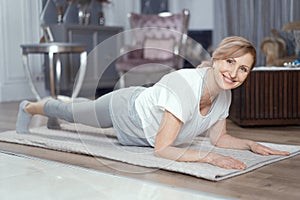 Beautiful mature woman stands in plank position