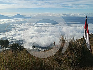 A beautiful meadow on a mountain with a sea of ??clouds all around