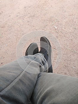 Beautiful meaningful iimage of a person who i ris sitting on a place wearing shoes