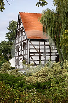 A beautiful medieval building with a red tiled roof among green trees