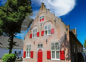 Beautiful medieval dutch gable roof house, red wood door and window shutters - Oisterwijk (Brabant), Netherlands