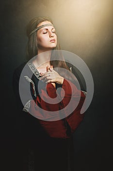 Beautiful medieval woman praying photo