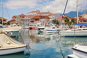 Beautiful Mediterranean landscape. Seaside town: houses with red roofs and fishing boats in harbor. Montenegro, Tivat city