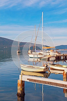 Beautiful Mediterranean landscape on sunny winter day. Small dock for sailboats and fishing boats. Montenegro, Kotor Bay