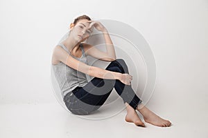 Beautiful melancholic girl sitting on the floor