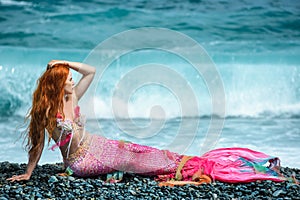 Beautiful mermaid on sea shore