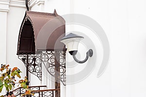 Beautiful metal old wall lamp hanging on a church, architecture, outside
