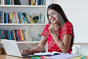 Beautiful mexican female student learning on computer