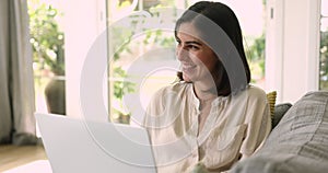 Beautiful Mexican woman studying or working on-line using laptop