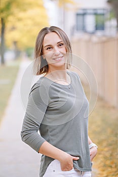 Beautiful middle age Caucasian woman with short hair walking in autumn fall street outdoor. Young woman with short haircut in