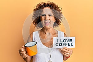 Beautiful middle age mature woman holding i love coffee banner clueless and confused expression