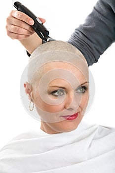 Beautiful middle age woman cancer patient shaving hair