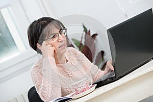 Beautiful middle age woman using laptop in home