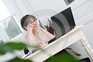 Beautiful middle age woman using laptop in home