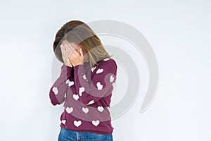 Beautiful middle age woman wearing heart sweater over isolated background with sad expression covering face with hands while