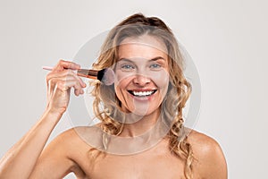 Beautiful Middle Aged Woman Applying Blush On Face With Makeup Brush