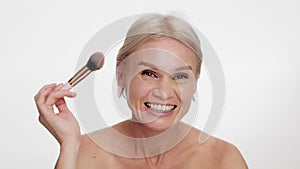 Beautiful Middle Aged Woman Applying Powder On Face With Makeup Brush