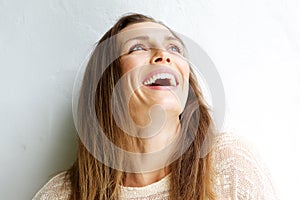 Beautiful middle aged woman laughing against white background