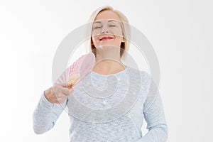 Beautiful middle aged woman with menopause blowing by fan. Hormone replacement therapy and mature woman healthcare. Mid age happy