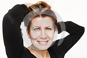 A beautiful middle-aged woman smiles on a white background with painted hair. Isolated