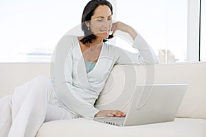 Beautiful middle aged woman using laptop at home