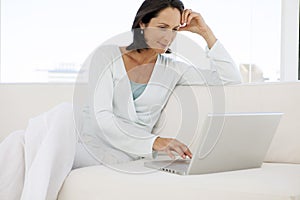 Beautiful middle aged woman using laptop at home