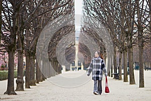 Beautiful middle aged woman walking in Parisian park