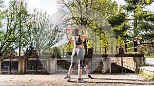 beautiful middle aged women doing exercises outdoors with a resistance band