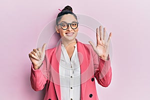 Beautiful middle eastern woman wearing business jacket and glasses showing and pointing up with fingers number six while smiling