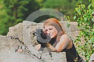 Beautiful military girl aiming a weapon based on the concrete cover