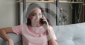 Beautiful millennial arabian indian woman enjoying pleasant mobile phone call.