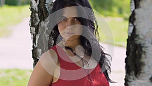 Beautiful milti racial woman looks in to camera in park outdoor confident female