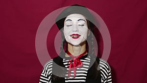 Beautiful mime girl nods her head affirmatively and says yes while looking at the camera.