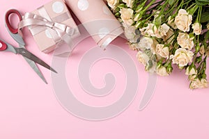 Beautiful mini roses with pink gift box and wrapping paper on a bright pink background. holidays. Valentine`s Day. women`s Day.