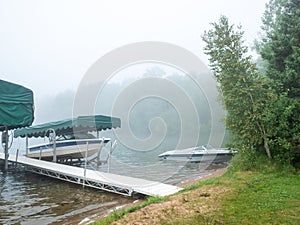 Beautiful Minnesota lake on a foggy morning with pleasure boats on shore