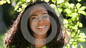Beautiful mixed race African American girl biracial teenager young woman outside smiling, laughing and turning to camera