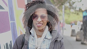 Beautiful mixed race girl with curly hair posing in urban city scenery