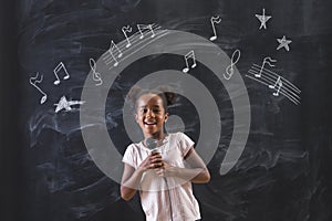 Beautiful mixed race schoolgirl singing in music class in school